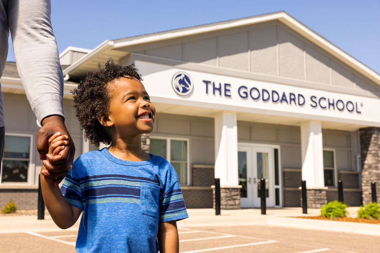 Child in front of school exterior